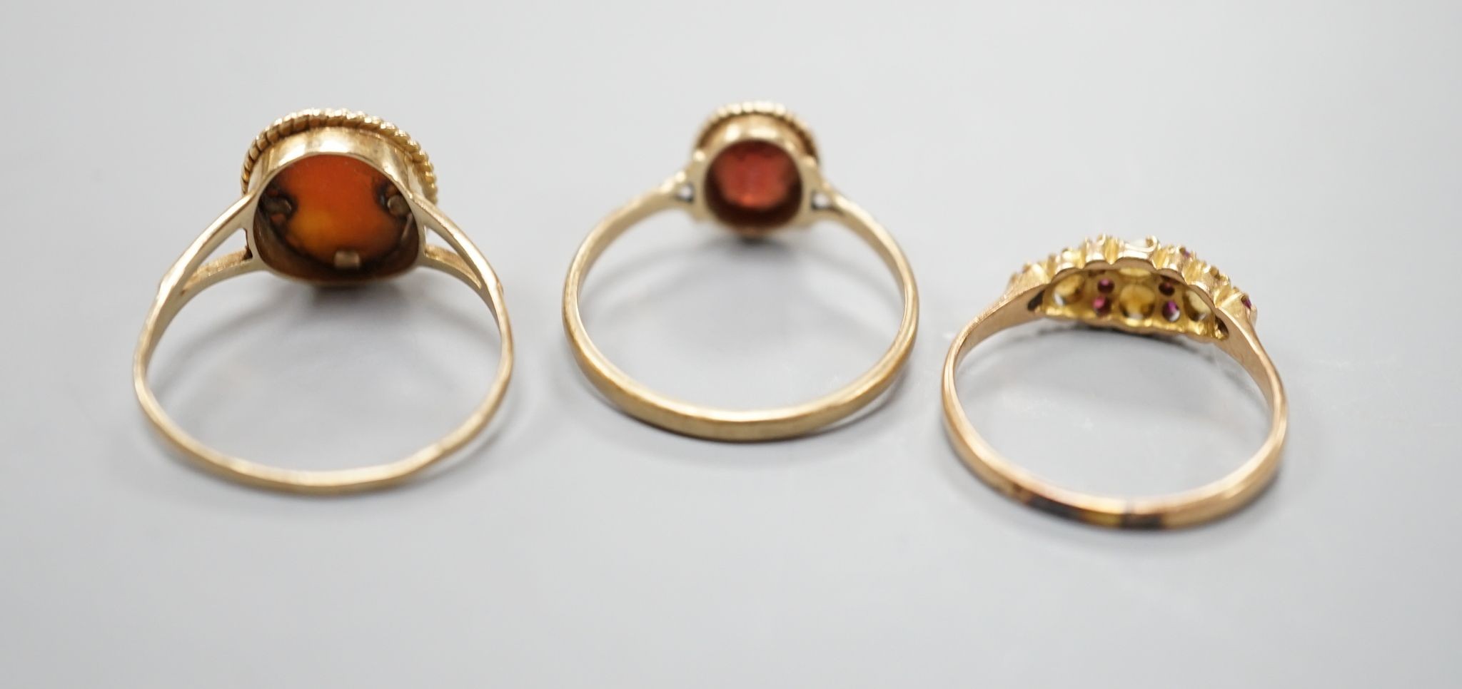 A late Victorian 15ct gold, seed pearl and amethyst cluster set ring, size L, gross 2.1 grams and two later 9ct gold rings including cameo shell, gross 3.2 grams.